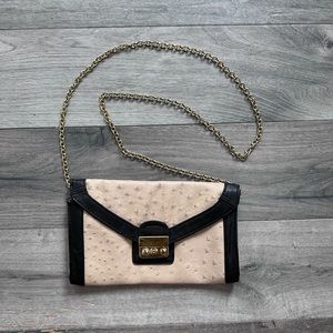 Nude clutch with gold chain.